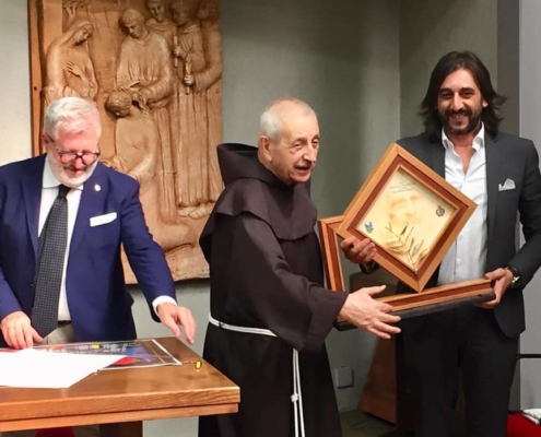 Padre Polidoro consegna la Palma d’Oro ad Enzo Muscia.